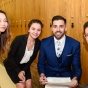 Picture of four upper-level law students dressed professionally in school hallway. 