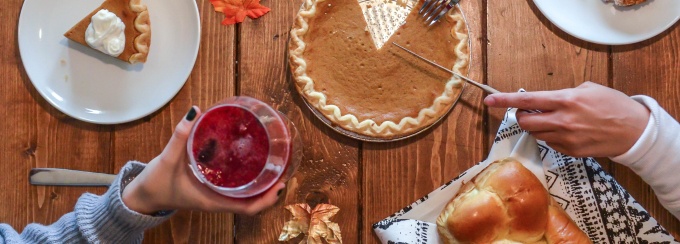 person slicing pie beside bread. 