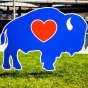 blue buffalo with red heart sign in front of buffalo, new york's canal-side harbor. 