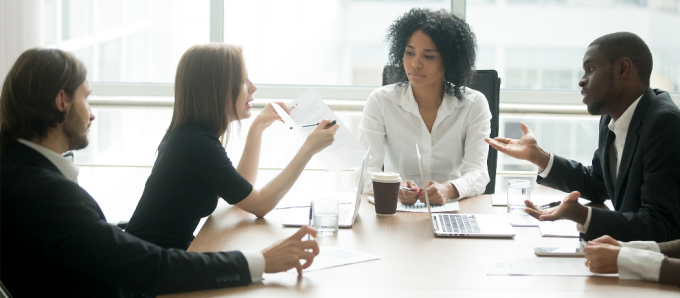 group of diverse people sitting around a table having an intense conversation. 