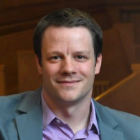 man sitting on court room bench, smiling. 