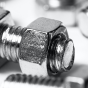 Close-up of scattered nuts and bolts on white background. 