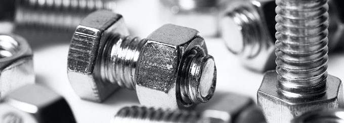 Close-up of scattered nuts and bolts on white background. 