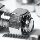 Close-up of scattered nuts and bolts on white background. 