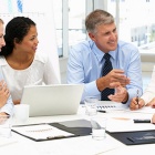 people sitting at a table, smiling. 