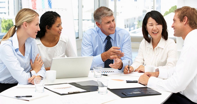 group of people around a conference table. 