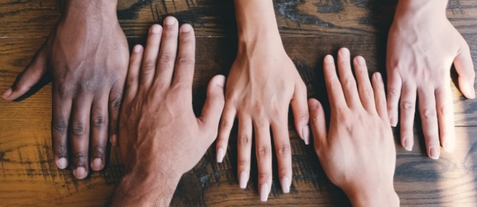 many hands on a desk. 