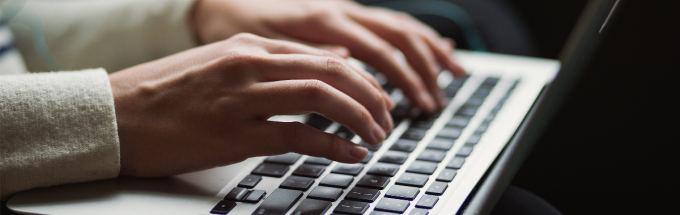 woman's hands on a laptop, typing. 