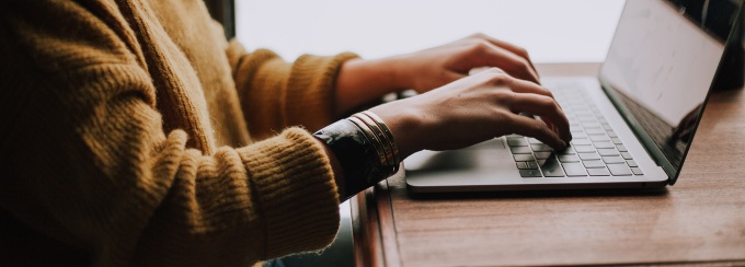 person typing into a laptop. 