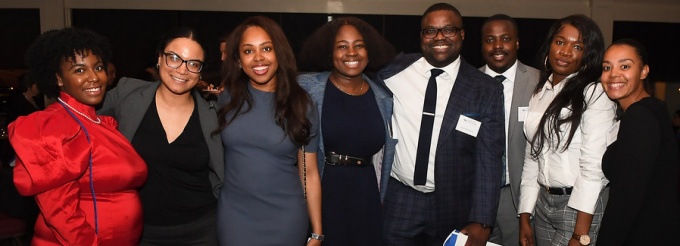 group of students standing together, smiling, attending an event. 