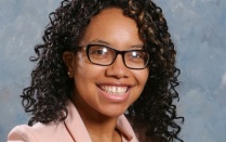 woman wearing glasses, smiling for her portrait photo. 