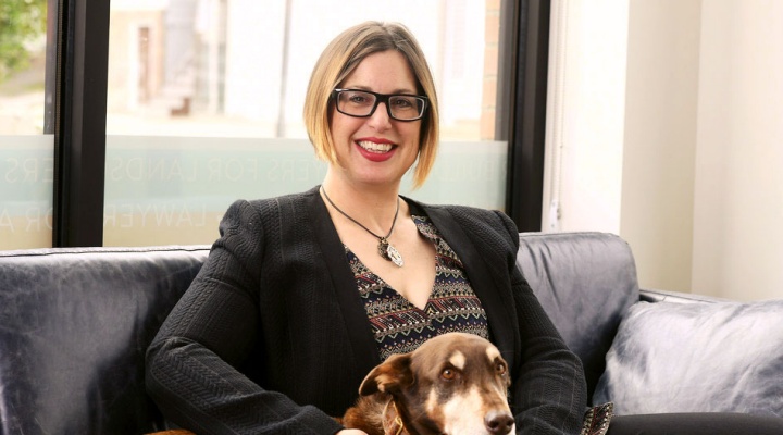 Stephanie Adams sitting on a sofa with her dog. 