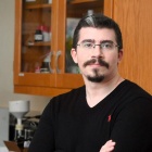 Jonathan Smyth standing in a research lab, leaning against a sink. 