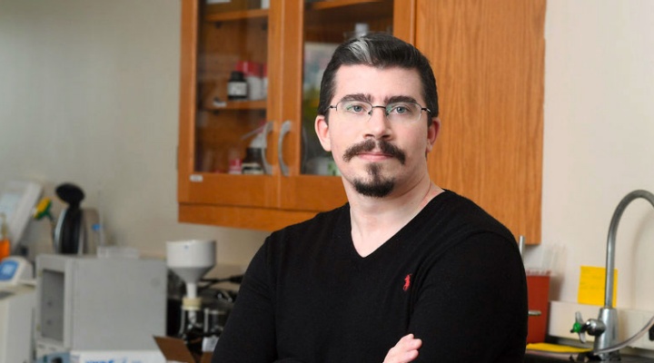 Jonathan Smyth standing in a research lab, leaning against a sink. 