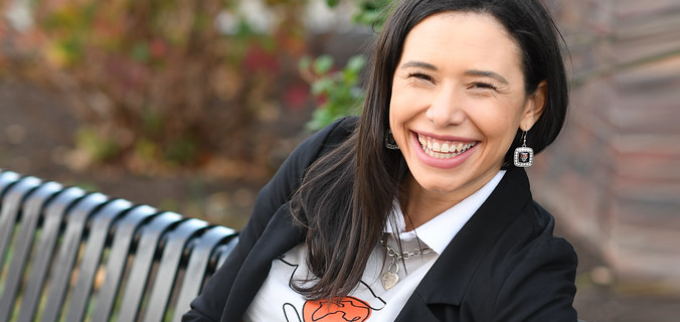 Talia Rodriguez sitting on a bench, smiling. 