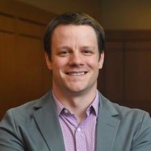 man standing in a court room smiling. 