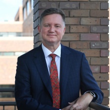 man standing outside smiling. 