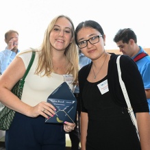 two women, one holding up an envelope. 