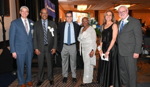 A group of well-dressed people, smiling, at a fancy event. 
