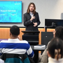 Man in front of a classroom with students listening. 