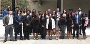 Group of young adults standing outside in a group, smiling. 