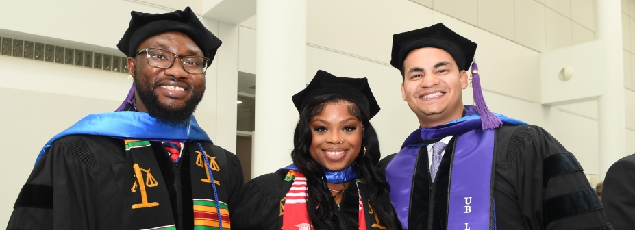 Three students at graduation. 