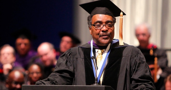 Judge Scott standing at a podium during a commencement ceremony. 