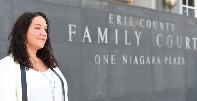 Image of student in front of Erie County Family Court sign. 