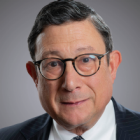 formal portrait of a man wearing a buisiness suit, tie and glasses. 