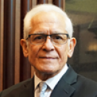 formal portrait of a man wearing a buisiness suit, tie and glasses. 