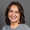 Woman wearing grey shirt, smiling.