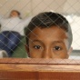 A boy looks out the door window from the room he is staying in at the Brownsville, Texas, port of entry. Photo by Edwardo Perez, courtesy of U.S. Customs and Border Protection. 