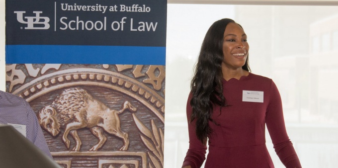 photo of Tolu speaking at a podium. 