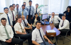 photo of Akbar sitting in an office with his co-workers. 