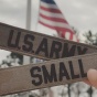 hand holds up army badges. 