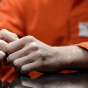 photo of inmate sitting with his hands on the table. 