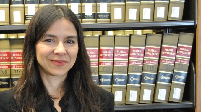 samantha barbas standing in the library in front of books. 