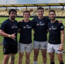 rugby players in a sports arena posing for a photo. 