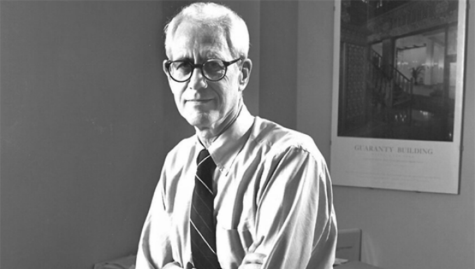 black and white photo of magavern sitting in his office. 