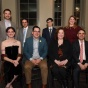 group of dinner attendees siting and standing for a photo. 