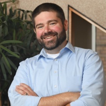 man smiling, arms crossed. 