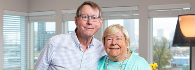 man and woman standing in a living room. 