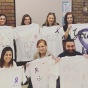 students holding up t shirts with motivational messages. 