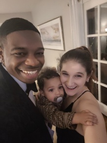 smiling family photo of Delroy, Rachael, baby Myles Pinnock. 