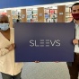 law students hold up a sign that reads Sleevs. 