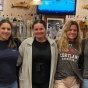 group of students posing for a photo in front of a bar. 