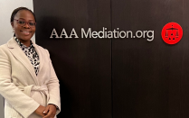 woman standing next to AAA Mediation sign. 