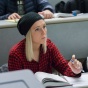 woman sitting at desk taking notes during class. 