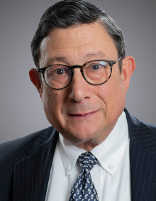 portrait of a man wearing a tie and glasses. 