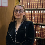 woman standing in front of a bookcase. 